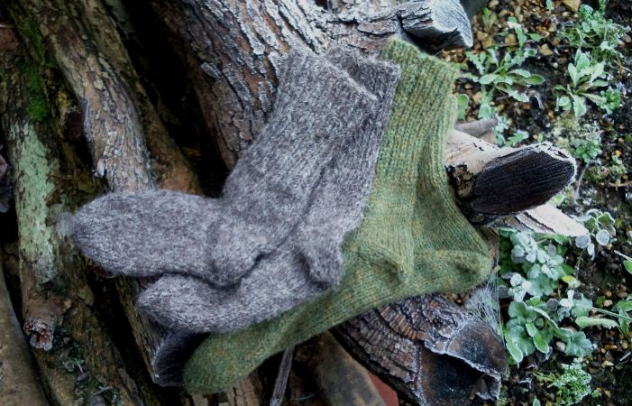 Herdwick Wool Socks: Image of pair of boot socks knitted in Herdwick wool (left) and pair of green pure wool socks of unknown wool type (right).