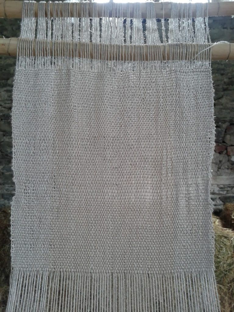 Warp-weighted Loom Weaving: Image of coarse-woven linen cloth on the loom