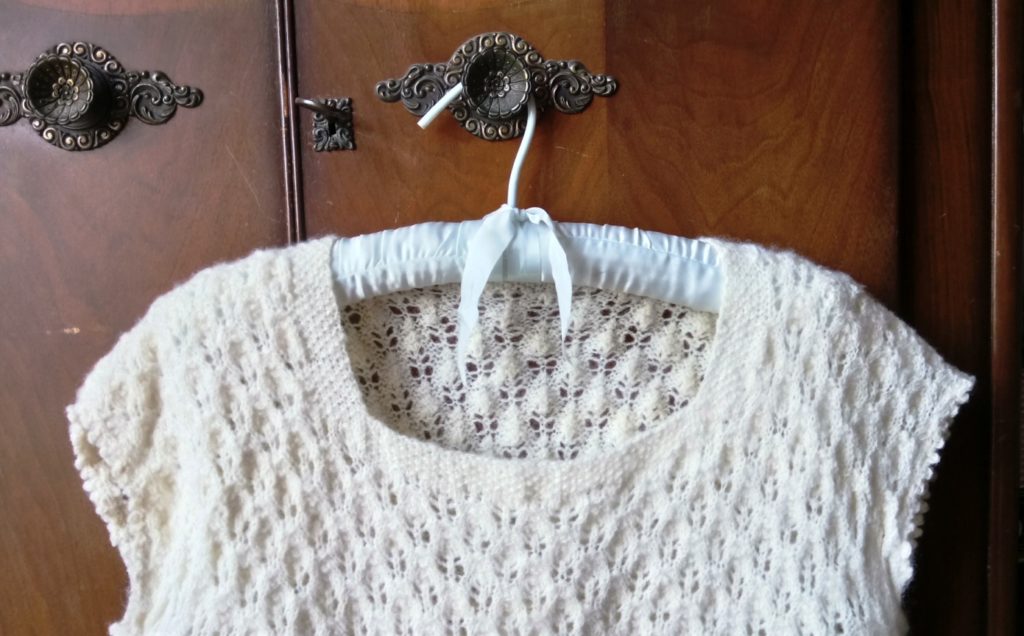 Sustainable wool bridal wear: image of vintage style handknit top, made from handspun Ryeland wool on a hanger