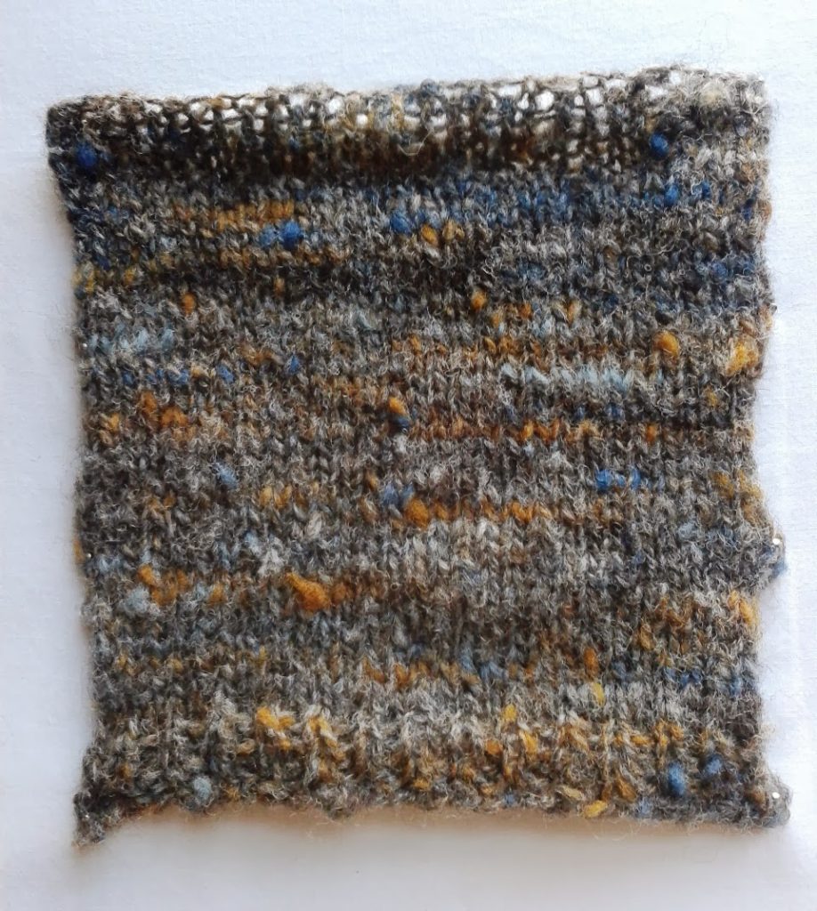 Swatch of tweedy yarn spun with flecks of carding waste