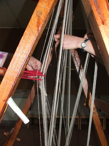 Tying the heddle strings on to warp threads