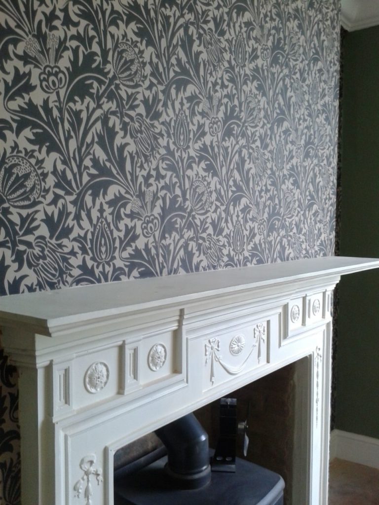 Second-hand cast iron fire surround (re-painted) and William Morris wallpaper