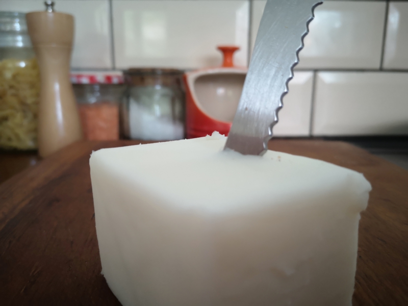 Zero waste fat and oil: block of lard on a bread board, ready to cut off a slice