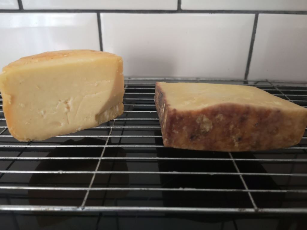 Store Cheese In the Pantry: Image of two blocks of cheese, cut edges wiped with distilled white vinegar, and left to dry on a baking rack