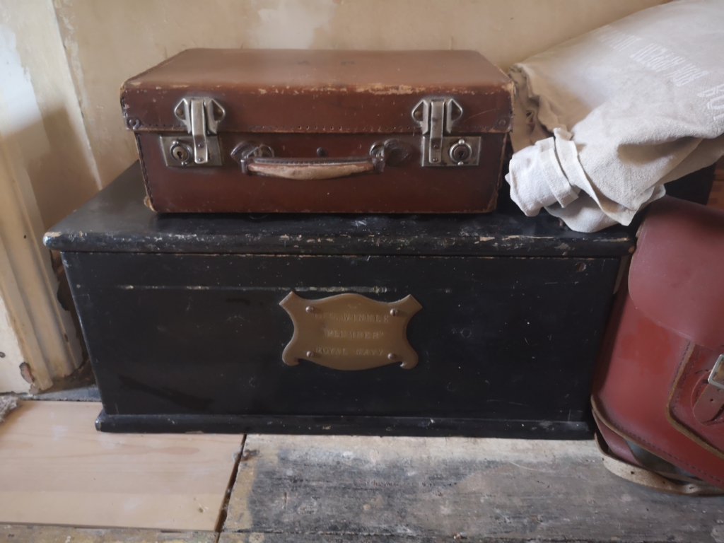 Regenerative goods: image of vintage goods (my family's). My grandfather's old suitcase, stuffed full of old photos, on top of his older brother's wooden toolbox