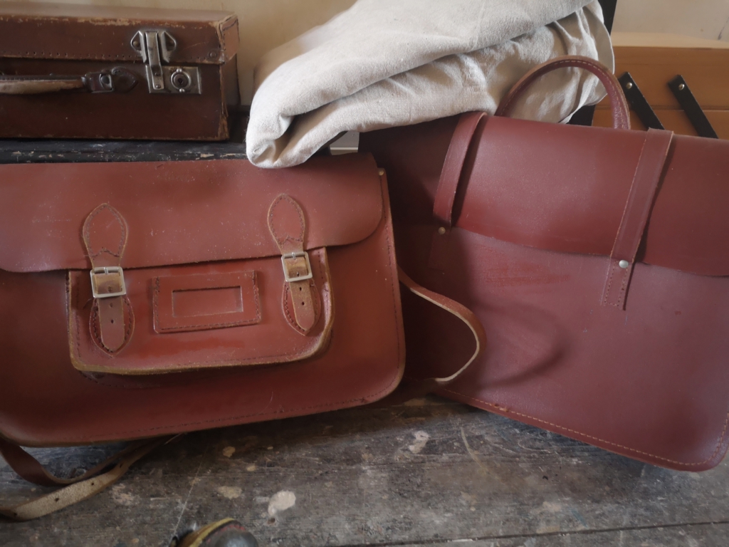 Regenerative goods: Leather goods - school satchel and music case (1970s) with an old small suitcase on top of an old wooden toolboxtool