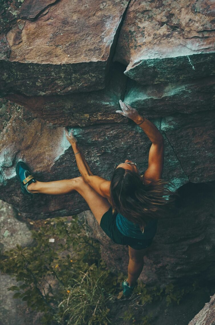 Truth Seeker; Truth Prospector analagy; a rock climber (woman) hanging off a rock face, testing a hand hold.